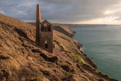 Sun setting over the former tin mine on the dramatic Cornwall coastline