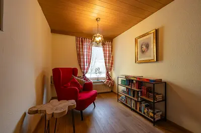 Leseecke mit Büchern und einem gemütlichen roten Stuhl