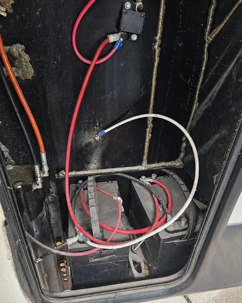 dirty unmaintained rv battery compartment that needs washed and electrical connections checked.