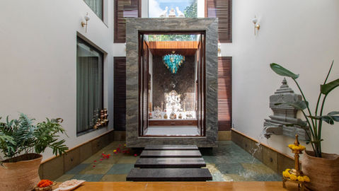 A Pooja Room with a waterbody around it and a bridge of stone steps. Sunlight falls on the Ganesha Idol.