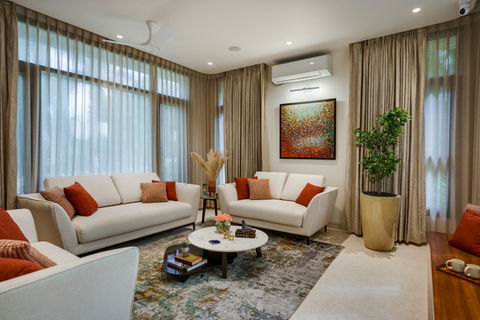 Opulent living room with neutral colored plush sofas, silk carpet and custom painting