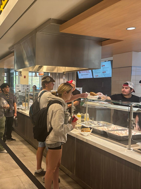 Students in line at a university dining hall counter.