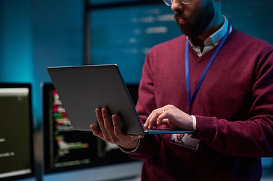 man holding laptop in office