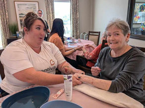 A caregiver offering hand massage to a resident.