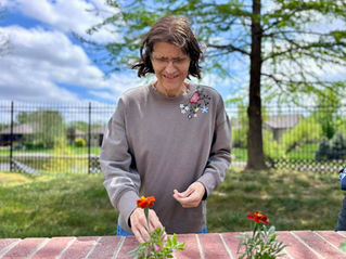 A resident plants flowers at ComfortCare Homes.