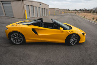 Side view of yellow McLaren Artura rental
