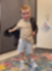 Young boy putting his coat on before he starts school