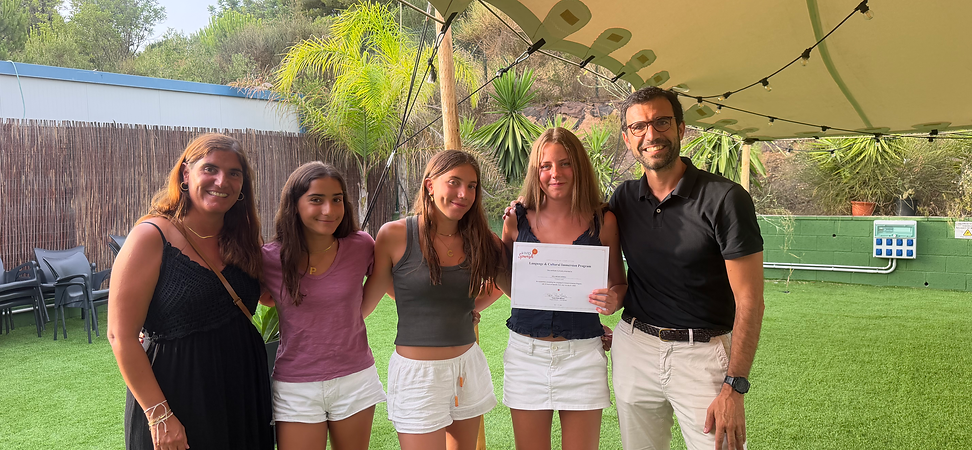 A student receiving her Summer certificate and her Spanish host family