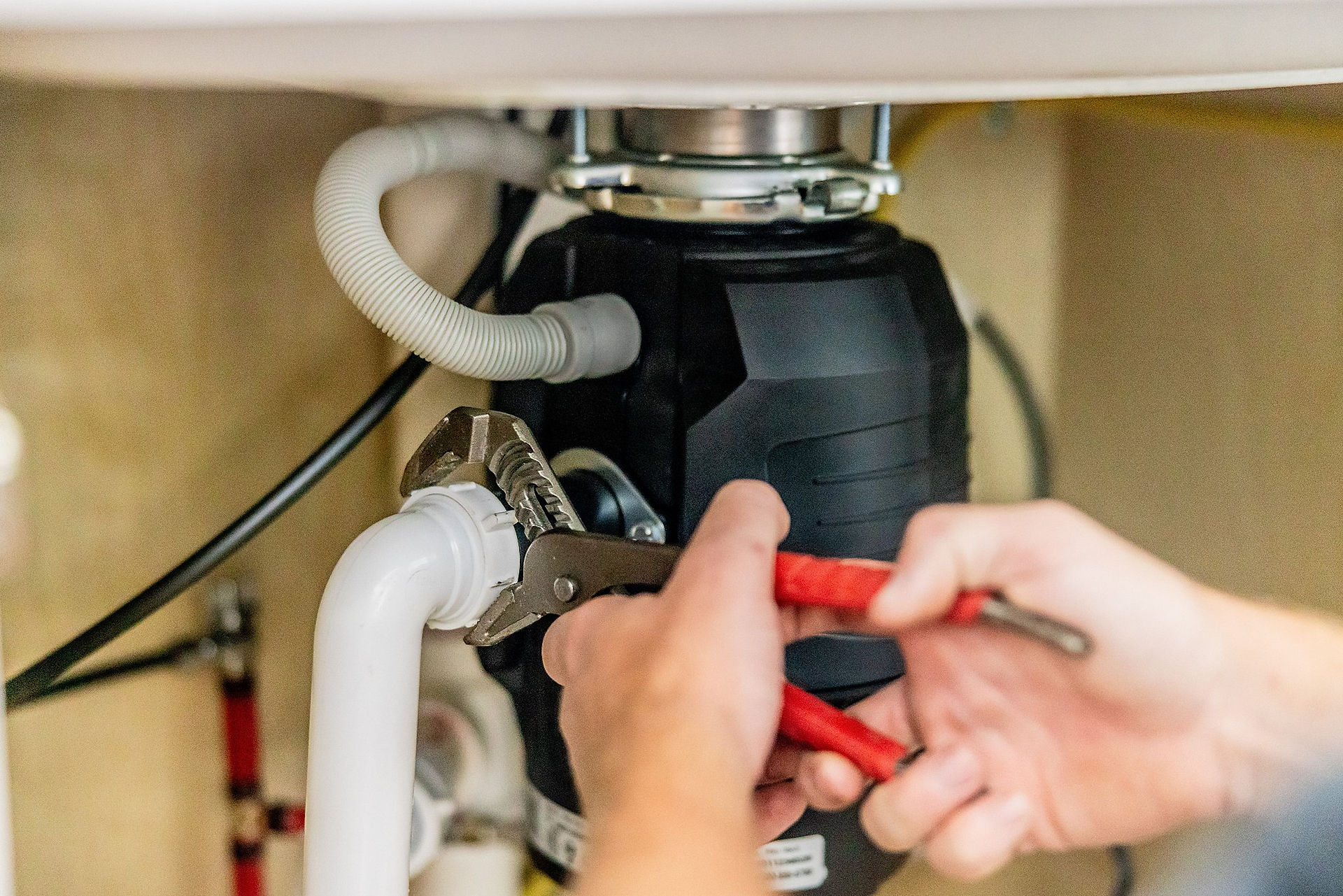 up close picture of man fixing sink pipes