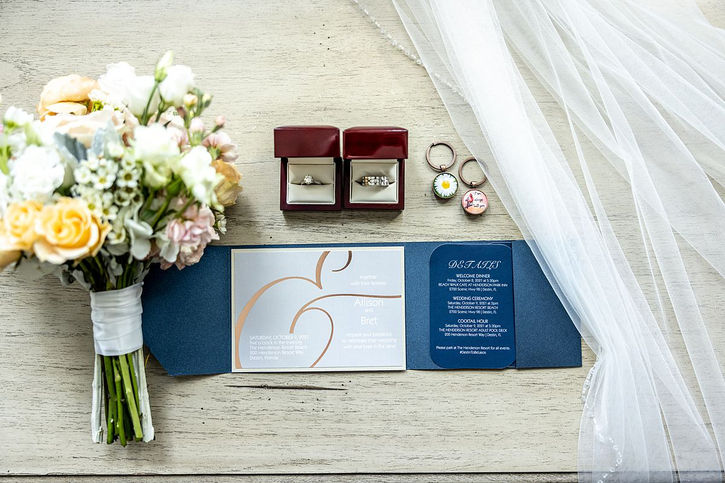flat lay of wedding invitation, florals, rings, and veil from photography by 30a photographer seagrove studios