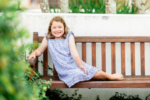 best Rosemary beach photographer little girl on the bench at Town Hall in rosemary