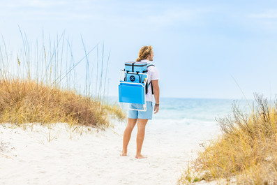 guy standing on 30A beach with cooler backpack
