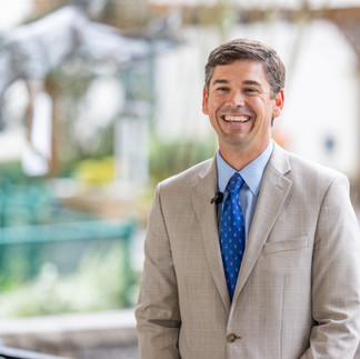 man smiling in front of park