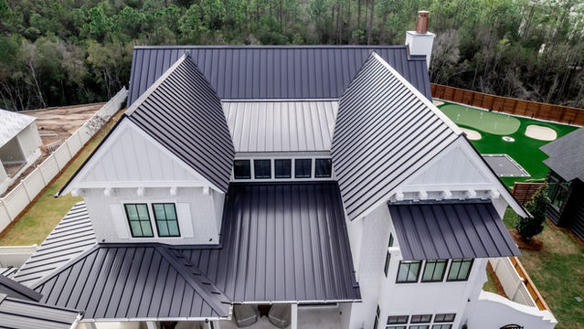 A large white house with a luxury metal roof and design