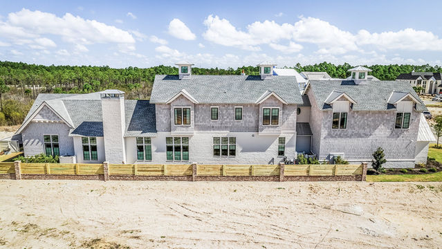A large white house with a luxury shingle roof and design