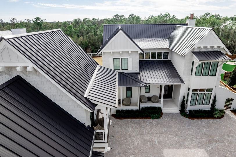 A large white house with a luxury metal roof and design
