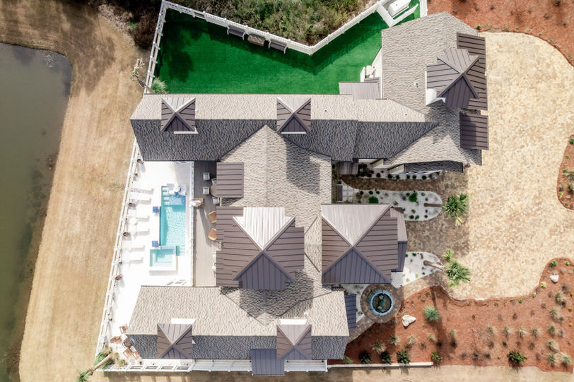 A large white house with a luxury metal and shingle roof and design