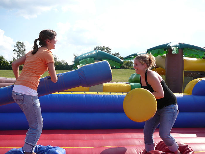 2 women playing on a inflatable interactive bounce house