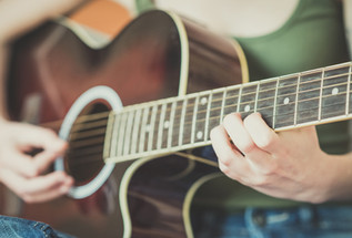 Close up of somone playing the guitar