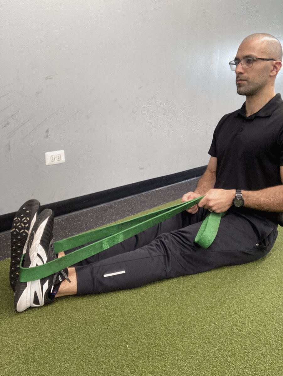 Using a strap to help lift the leg with neutral lumbar posture.
