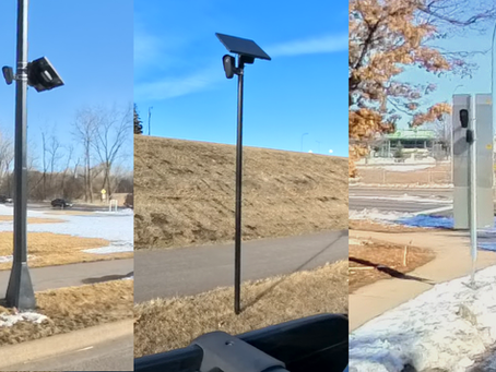 Three cameras placed on different poles, one behind a sign