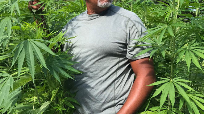 Derick standing in a hemp field