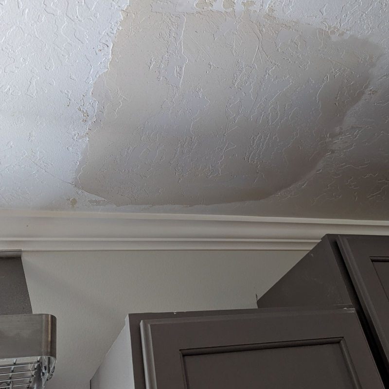 Expertly matched skip trowel drywall texture on a repaired ceiling above kitchen cabinets in Spanish Fork.