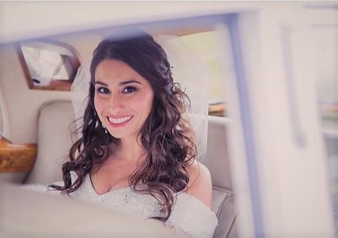 Brunette bride with curled hair in car