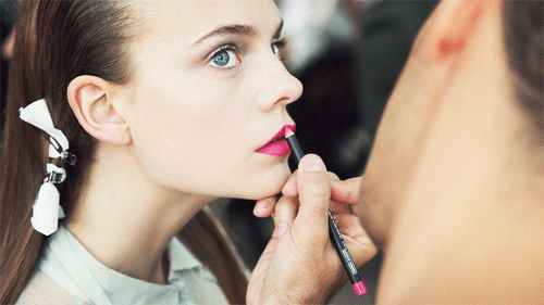 woman getting lipstick applied