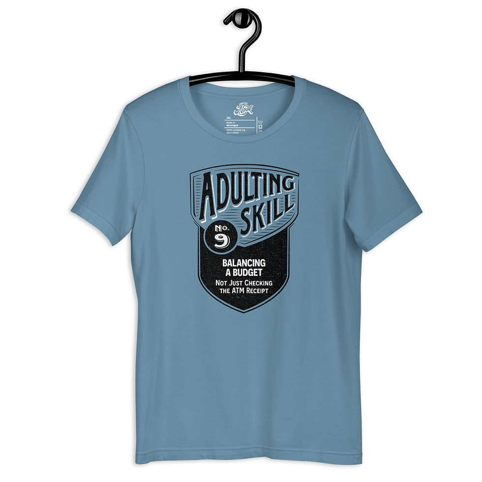 Thumbnail: Blue t-shirt with a black shield-shaped design that reads Adulting Skill 43 Getting a AAA Membership Under My Very Own Name.