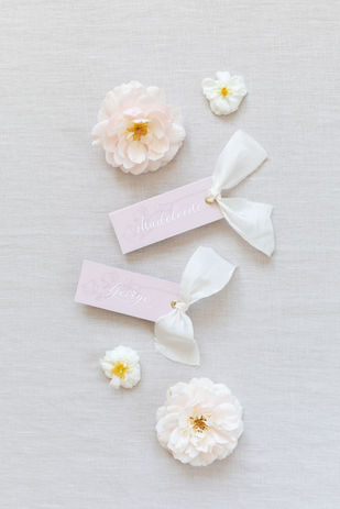 Pale pink calligraphy place tags with silk ribbon tied