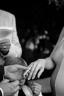 a young boy pulls a silly face as his parents exchange rings during wedding ceremony