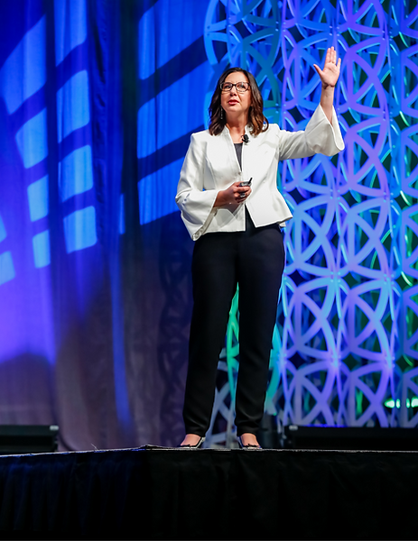 Generational expert Sarah Sladek speaks onstage in a white blazer and black slacks.