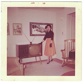 Woman, dressed up (Going Out?), poses in front of TV, 1959.