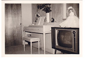 Portrait of interior, piano and TV with doll next to each other, circa 1960-63.