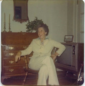 Women mugging for camera, with TV and desk in living room setting, circa 1972-77.