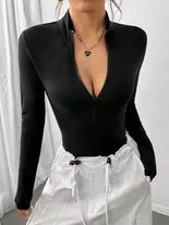 Woman in black zip-up collared bodysuit, partially unzipped, with white cargo pants