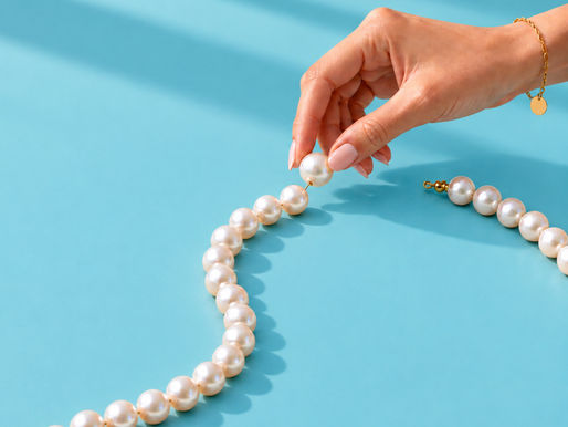 A woman adding a pearl to a strand of pearls