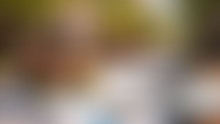 Lincoln Square Chicago street scene with a model brick house placed on real estate financial charts, calculator, keys, and magnifying glass on a wooden desk, representing local market analysis and property investment evaluation.