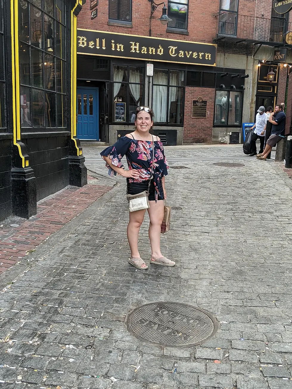 Author A.K. Vande Vorde standing by the Boston manhole on Creek Square in "The Boston Revolutionary Art and Teacup Society."