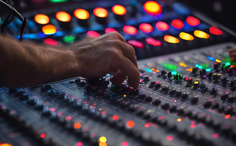 A close-up shot of a professional mixing console or digital soundboard in action, with col