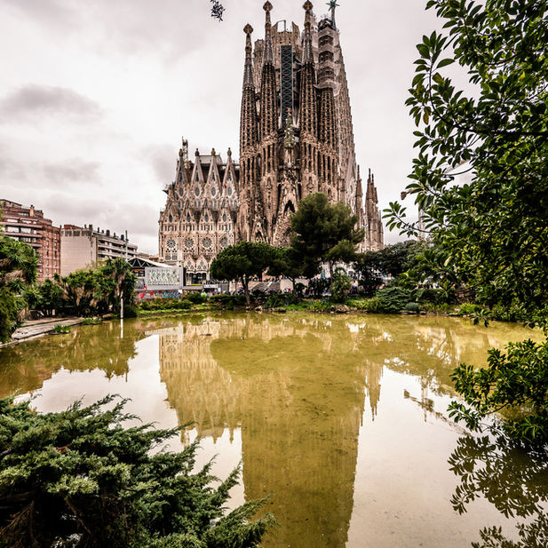 La Sagrada Familia /The grand exterior of the Sagrada Família Basilica in Barcelona, showing its towering spires and intricate stone facades designed by Antoni Gaudí.