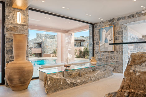 Luxurious stone interior with large window and pool view.