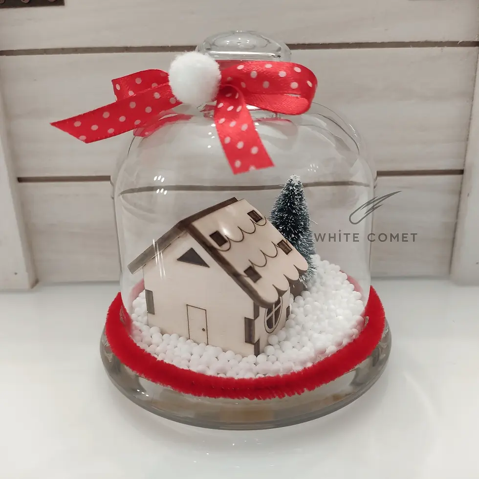 Miniatura: Mini campana di vetro con casetta in legno, albero innevato e neve artificiale, decorata con fiocco rosso a pois e pompon