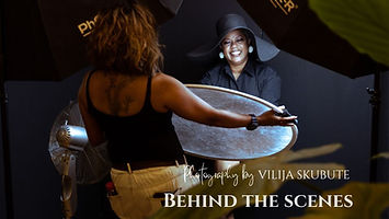 Behind the scenes of a 40 Over 40 portrait session with Vilija Skubute, showing a woman smiling under studio lights while an assistant holds a reflector during the shoot.