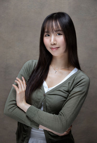 Female architect headshot in green cardigan.