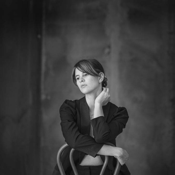 Femme brune posant, sur une chaise, portrait signature à Toulouse, NR PHOTOGRAPHIES