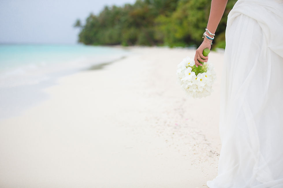 The bride walks on the beach of tropical island with beautiful bouquet of flowers.jpg