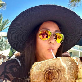 Kimberly Jacoby, CEO and co-owner of Romantics Travel, enjoying a tropical drink on vacation
