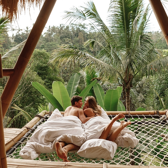 Happy travel couple on hammock balcony of bamboo tree house with jungle nature view vacati
